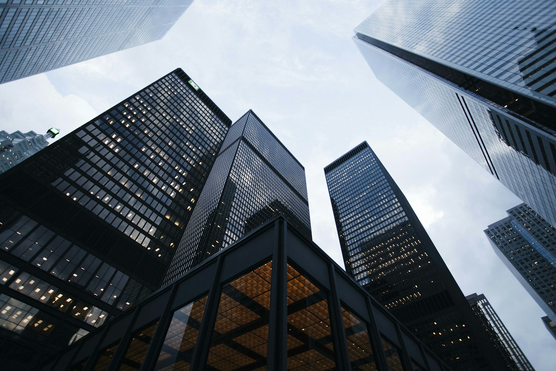 Façades vitrées de tours de bureaux vues en contre-plongée.